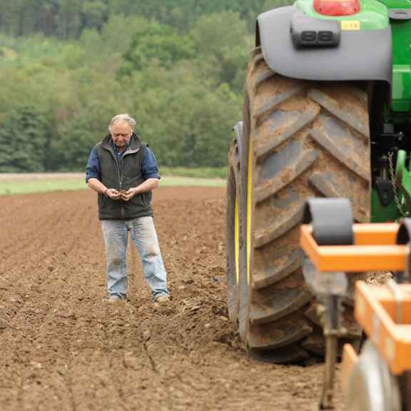 Boer in landbouwveld en tractor