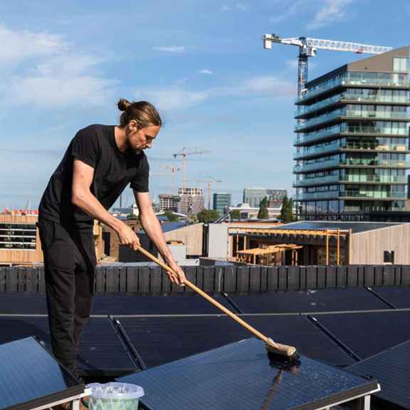 Man wast zonnepanelen op dak