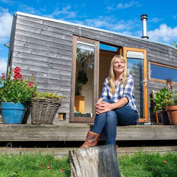 Marjolein Jonker zit voor haar tiny house. Foto: Lopke van de Reijt