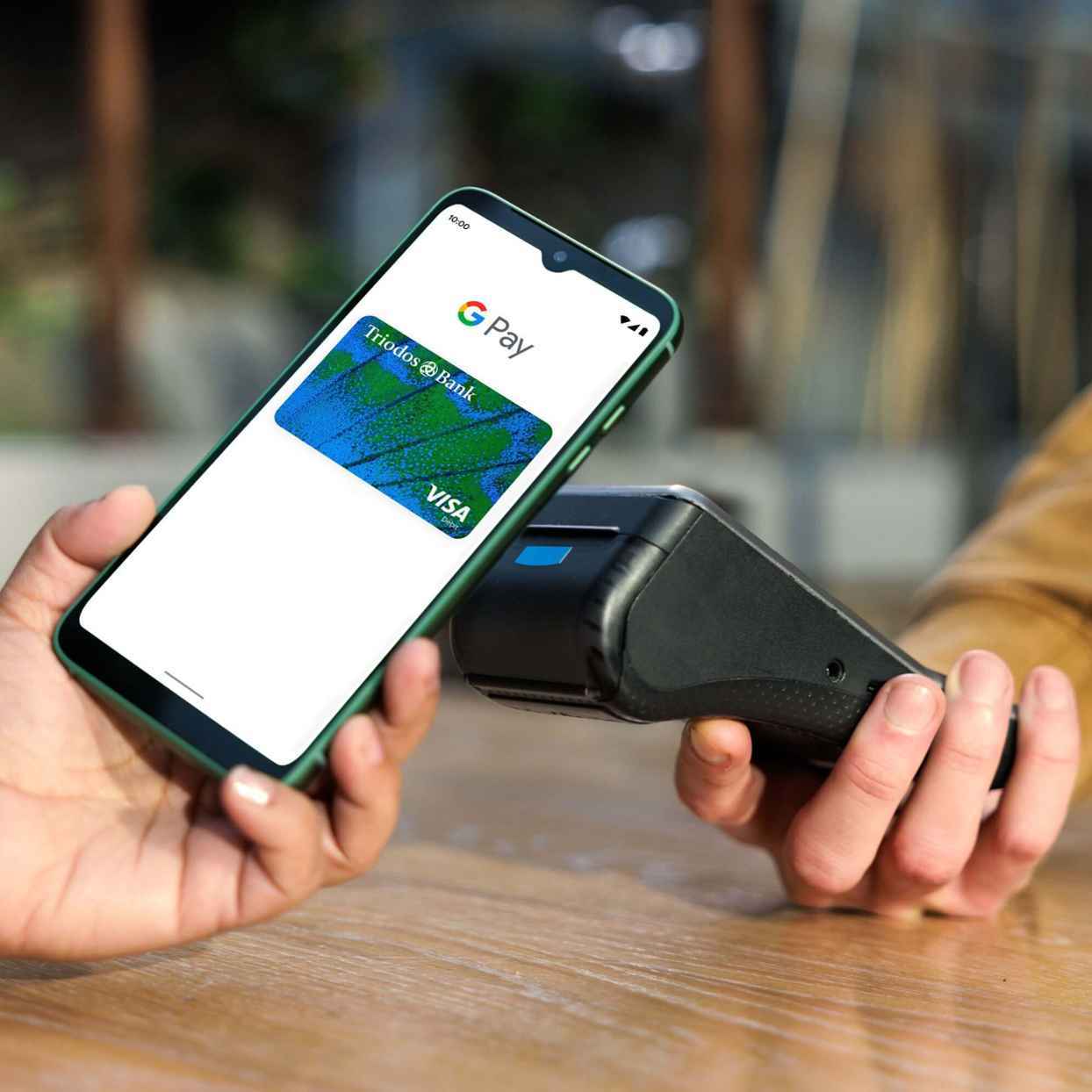 Iemand betaalt met de Triodos Betaalpas via Google Pay op mobiel in een winkel