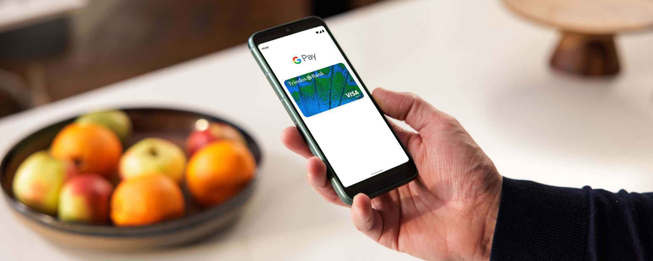 Iemand laat de Triodos Betaalpas in Google Pay op een mobiele telefoon zien