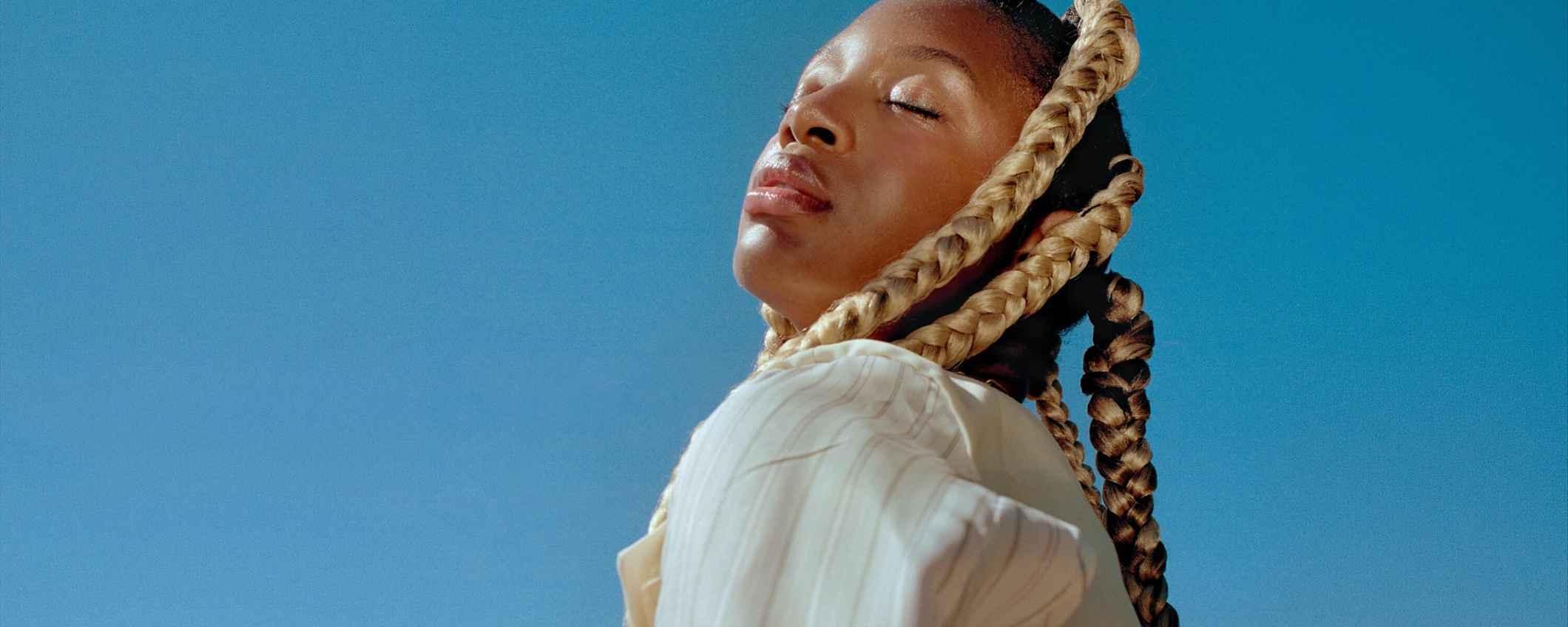 Vrouw met grote vlechten geniet van de zon