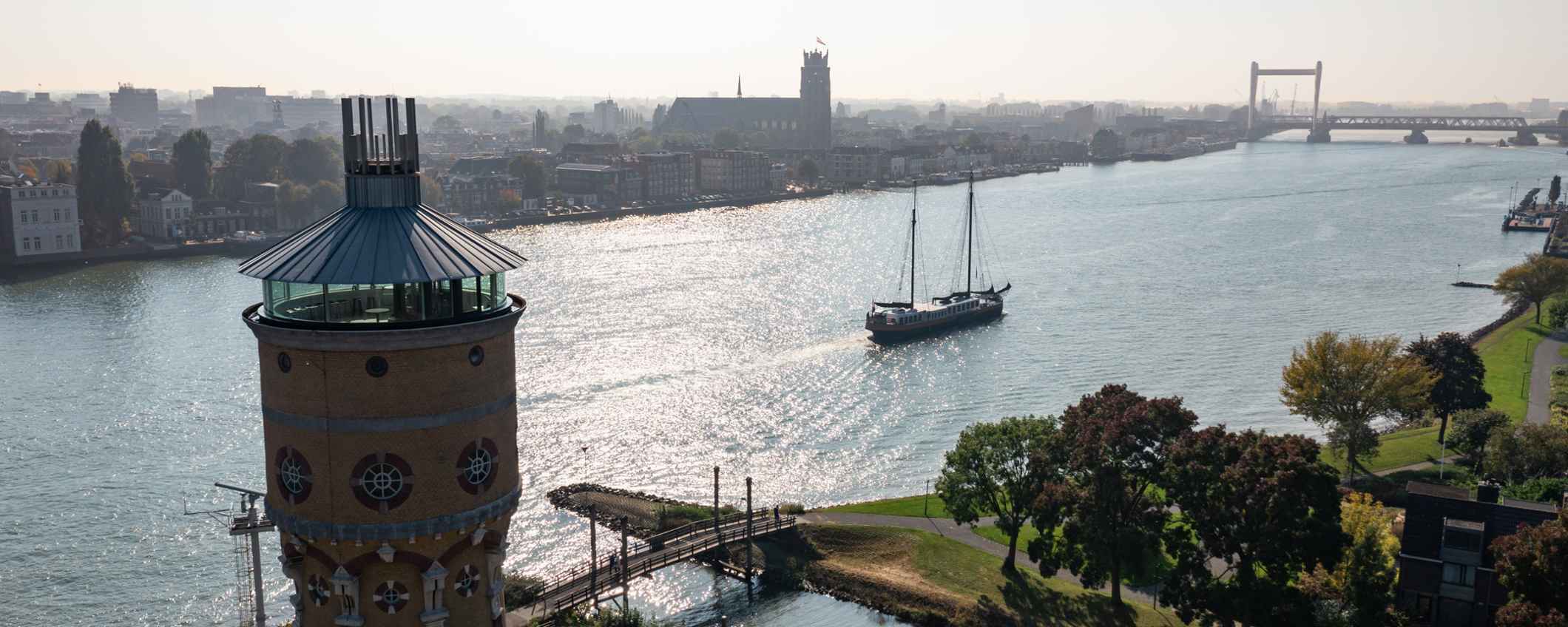 Luchtfoto van een kanaal met een silo, een schip en omringende huizen.