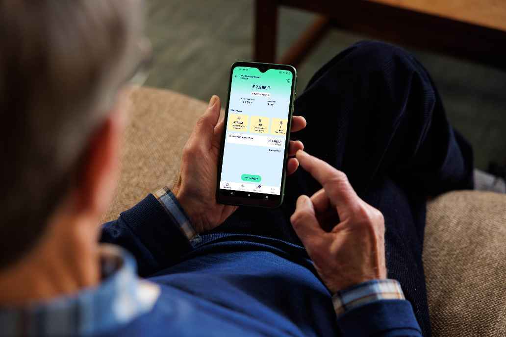 Man met telefoon kijkt naar beleggersrekening