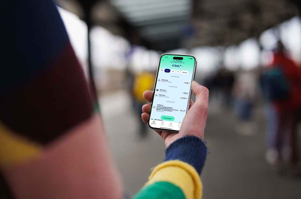 Man met telefoon kijkt naar betaalrekening