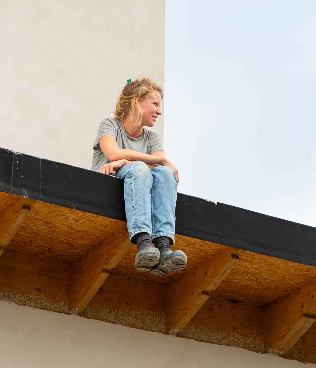 Sasja voet zit op het dak van haar huis, met haar benen over de rand