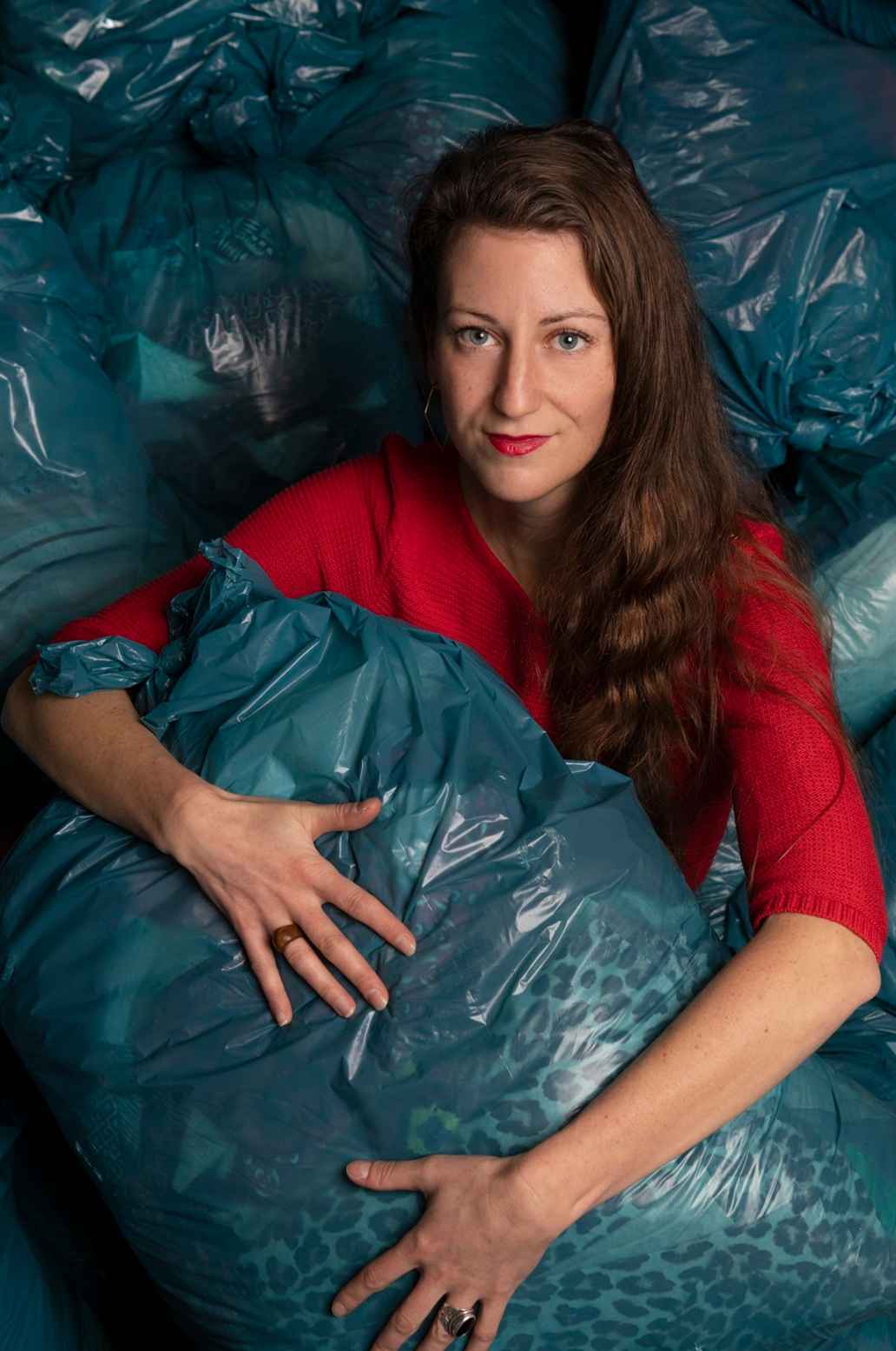 Elisah Pals in een berg afvalzakken.